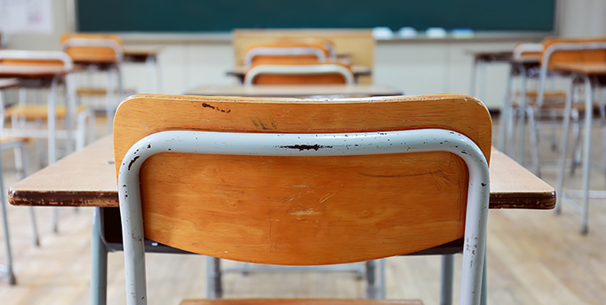 Back of a desk and chair in the back of a classroom 