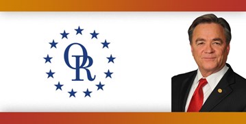 ORT logo with image of man with brown hair, wearing suit with red tie.