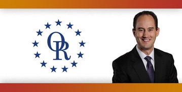 ORT logo with image of smiling man with brown hair wearing a suit.