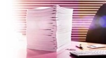 A stack of white papers on a desk.